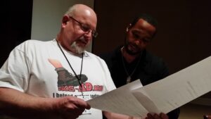 Two men reviewing a document together indoors.