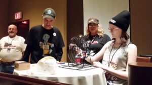 Three people play bingo at a table in a casual setting.