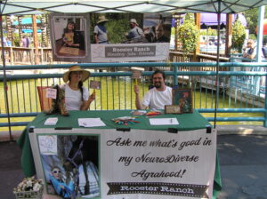 Two people at a booth promoting positive community action.
