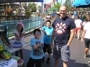 A happy family enjoying a sunny day at an amusement park.