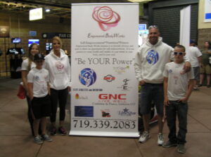 Group of people standing beside a banner at an event.