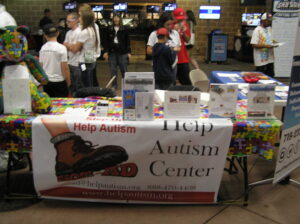 Volunteer at a Help Autism Center fundraising table.