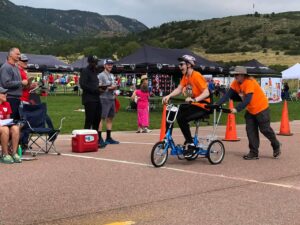Children enjoy an outdoor event with scooters and games on a sunny day.